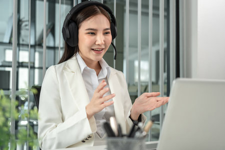 Female call center provides information to a customer calling for help, Contact us, Service with a beautiful and friendly voice, Long distance communication, Talk using headphones or headsets.の写真素材