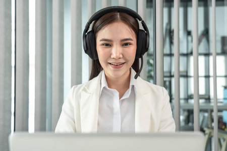Female call center provides information to a customer calling for help, Contact us, Service with a beautiful and friendly voice, Long distance communication, Talk using headphones or headsets.の写真素材
