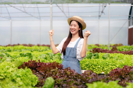 Woman smart farmer working and checking organic hydroponic vegetable quality in greenhouse plantation to management preparing export to sell.の写真素材
