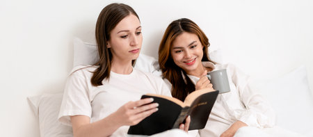 Young asian couple woman reading literature or a book together and drinking hot chocolate while...