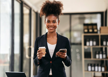 African american businesswoman in suit drinking coffee and reading accounting information of new...