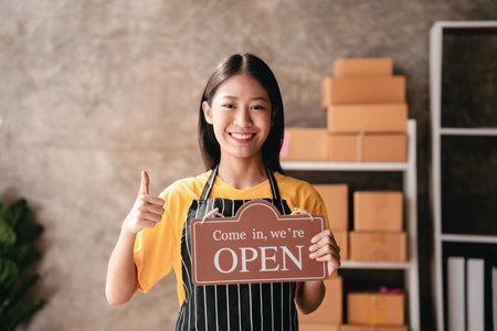 Small business parcel delivery concept, Female entrepreneur holding open sign to ready for service...