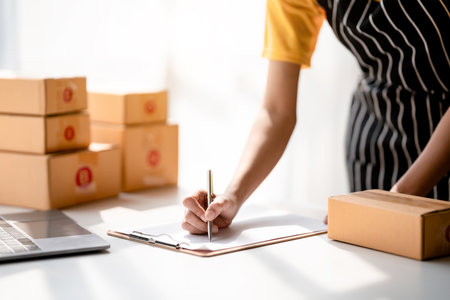 Small business parcel delivery concept, Female entrepreneur writing information on clipboard while...