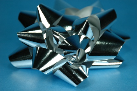 Shiny silver bow against blue bakcground