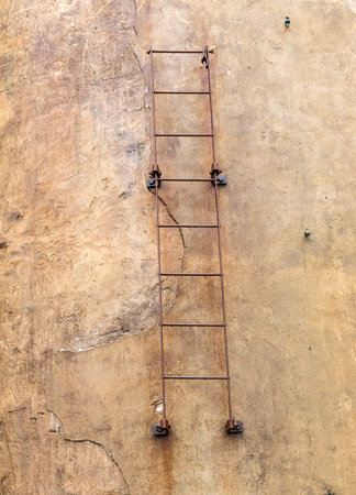 Ladder on the wall of an old building. View from below.の写真素材