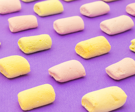 Pattern with yellow and purple yummy marshmallows on violet backgroundの写真素材