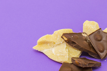 Milk chocolate with almond and cocoa butter on violet backgroundの写真素材