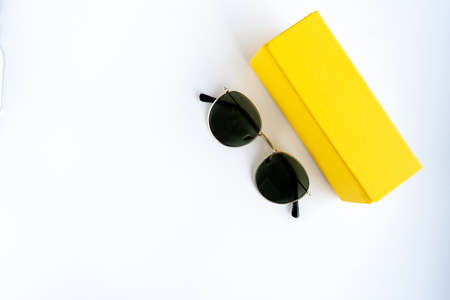sunglasses on a white background in a yellow case. Place for your text.の写真素材