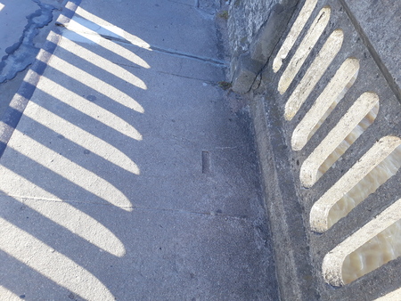 wall and its shadow, side by side, registered on the pavement floorの写真素材