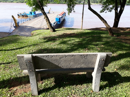 a concrete bench facing the river with a raftの写真素材