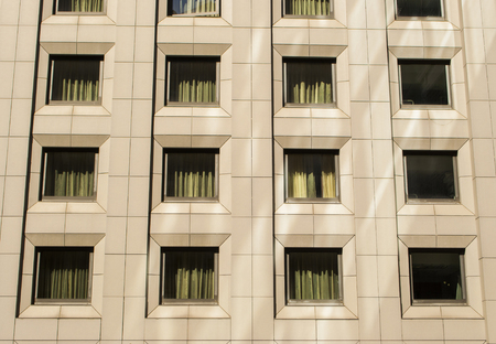 Multiple of square glass closed windows on a large office building.の写真素材