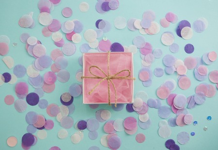 Multicolored confetti and sparkles on blue background.の写真素材