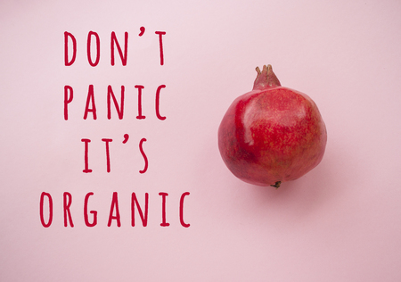 Flat lay of ripe red pomegranate fruit on a pink background with copyspace. Healthy food concept.の写真素材