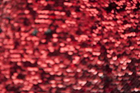 Red glittery defocused background with blinking details.の写真素材
