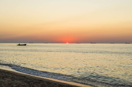 Beautiful sunrise on the sea shore on sandy beach.