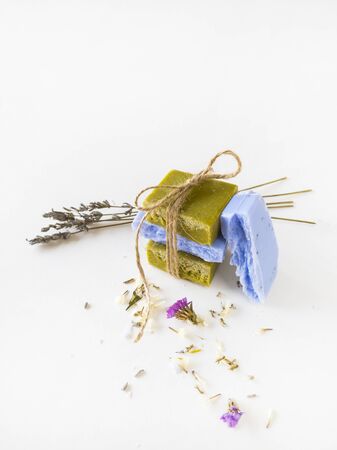 Homemade lavender and olive soap bars and lavender flowers on white background. Set of plastic free and zero waste body care items.の写真素材
