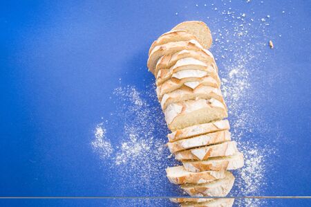 Freshly backed sliced bread on classic blue background with copyspace. Food concept.