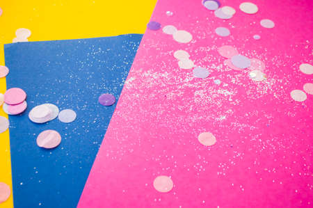 Colorful confetti, sparkles on bright pink, yellow and classic blue background. Blurred festive background.の写真素材