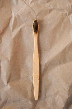 Bamboo toothbrush on beige background.