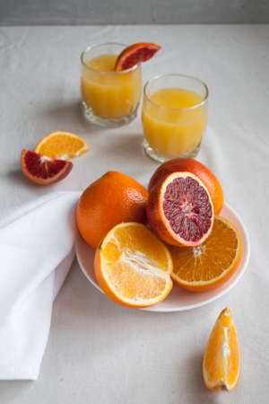 Fresh delicious cut variety of oranges on a hite plate.の写真素材