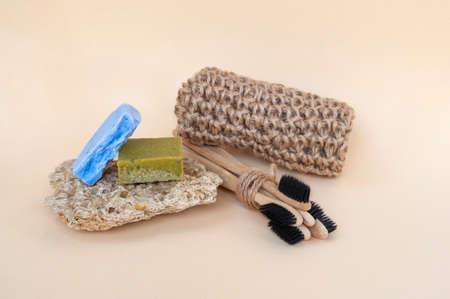 Zero waste bathroom accessories - toothbrushes, natural soap and knit twine scrubber on a beige background. Sustainable lifestyle concept.の写真素材