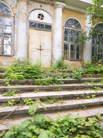 Old beautiful abandoned building in a green garden with mossy stairs.の写真素材