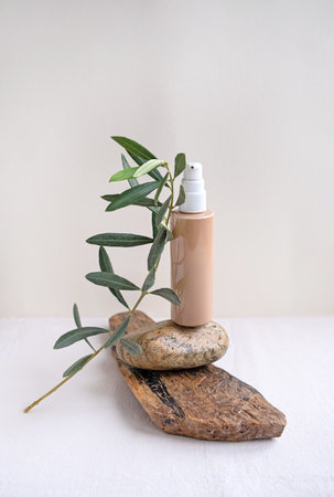Natural cosmetic bottle of cream balancing on beige color pebble.の写真素材