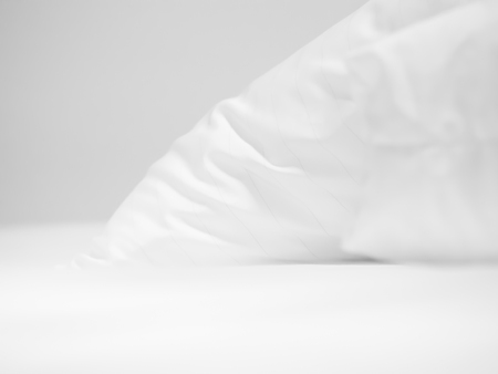 Closeup of white pillow on bed in bedroom.の写真素材