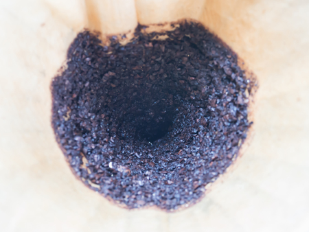 Abstract and closeup of used coffee filter and ground coffee beanの写真素材