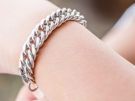 Closeup of stainless steel bracelet and girl handの写真素材
