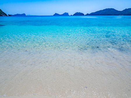 Horizontal lines of sand, clear blue sea and sky.の写真素材
