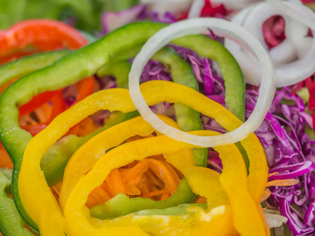 Closeup of red and green sliced sweet peppers and white onion salad.の写真素材