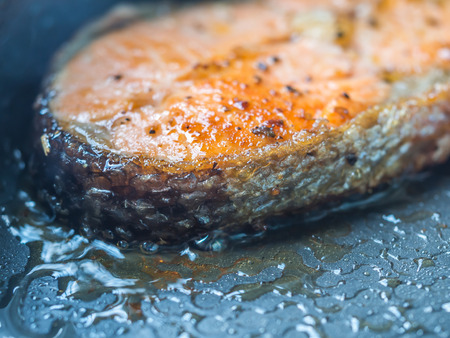 Seafood cooking. Closeup of sliced salmon fishes grilled on the pan.の写真素材