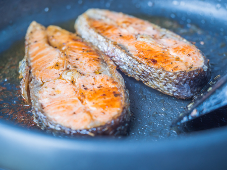 Seafood cooking. Closeup of sliced salmon fishes grilled on the pan.の写真素材