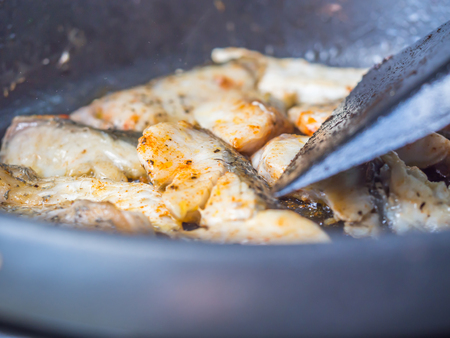 Seafood cooking. Closeup of sliced sea bass fishes grilled on the pan.の写真素材
