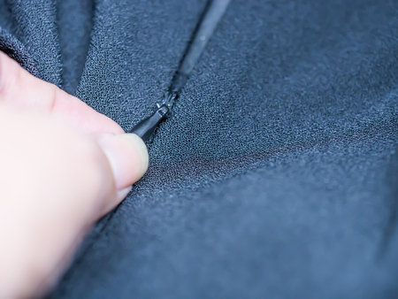 Closeup of hand and zipper of black dress.CAMERAの写真素材