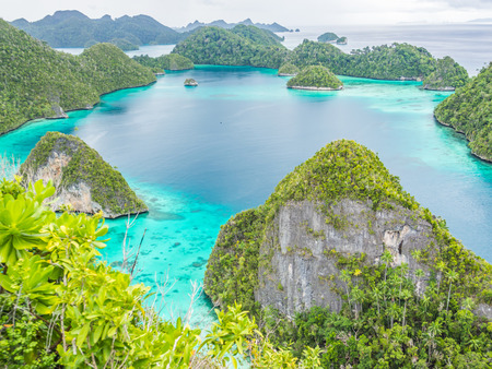 Wonderful island shape with forest, clear turquoise sea or lagoon and cloudy day.