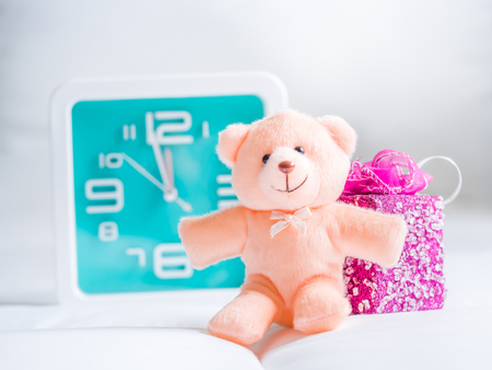Teddy bear toy clock and gift on fabrics background. Concepts and ideas for countdown time.の写真素材