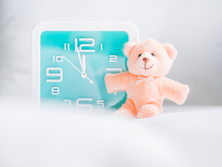 Teddy bear toy and clock on fabrics background. Concepts and ideas for countdown time.の写真素材