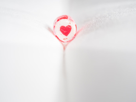 Closeup of heart shape candy cane with blurry grey fabrics backgroundの写真素材
