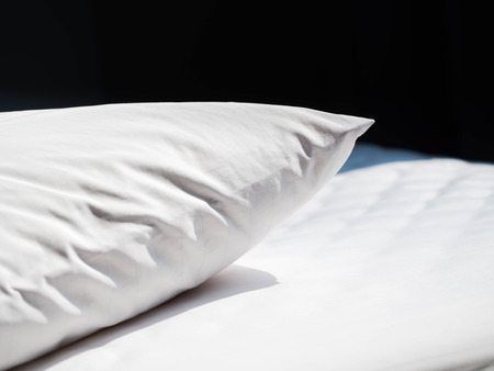 White wrinkles dust mites pillow and bedding cover with black background in the bedroom.の写真素材