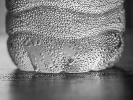 Black and white tone. Plastic bottle of drinking water on wooden table.の写真素材