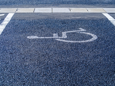 ?Handicapped parking sign or symbol painted on asphalt texture.の写真素材