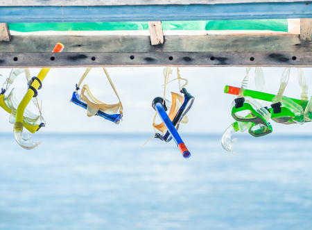 Focus at dirty masks and snorkels for rentwith blurry sea and sky background