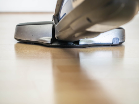 Closeup of portable or handheld vacuum cleaner and wooden floor.の写真素材