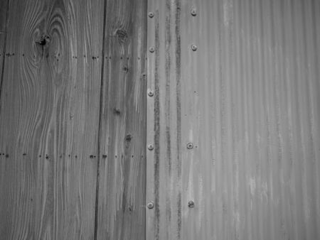 Abstract black and white background. closeup of old aluminium zinc sheet and wooden wall texture with wave or vertical striped pattern.の写真素材