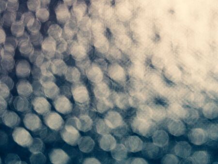 Cross processed tone effect of abstract blurry bokeh, bubbles and glitter background.の写真素材