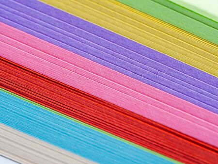 Abstract and closeup of vivid and vibrant multicolored stacked paper background. Colorful and...