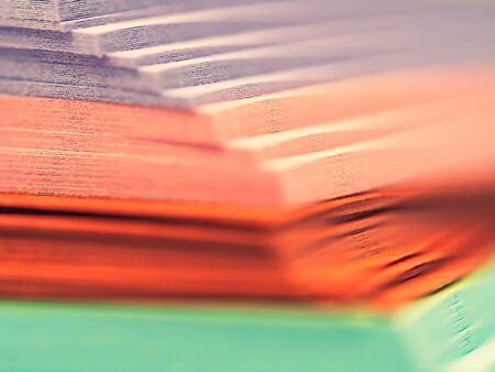 Abstract and closeup of pastel multicolored stacked paper background. Colorful and cheerful striped...