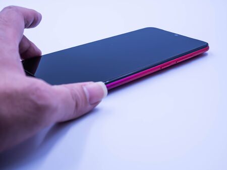 Closeup of smartphone and woman 's hand on gray background. Technology, shopping online, eCommerce,...